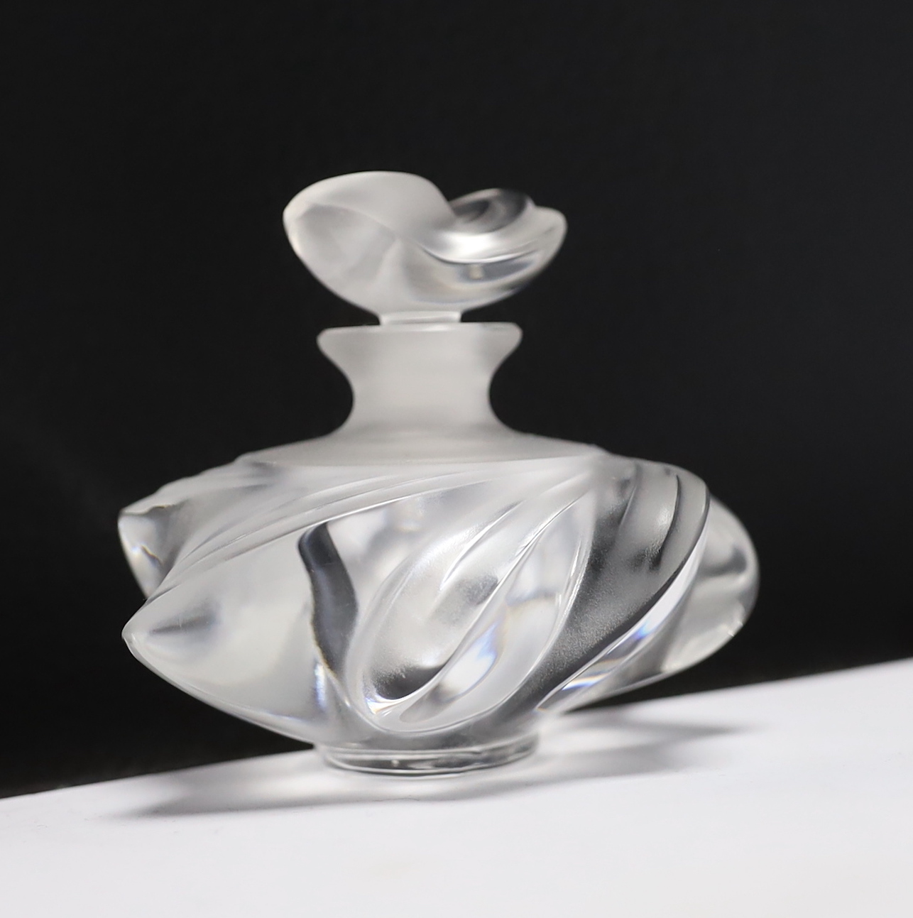 Three Lalique glass scent bottles and stoppers, one with Lily of the Valley stopper, 12cm